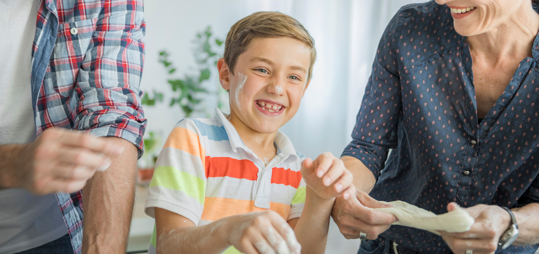 Kid laughing with parents whie cooking