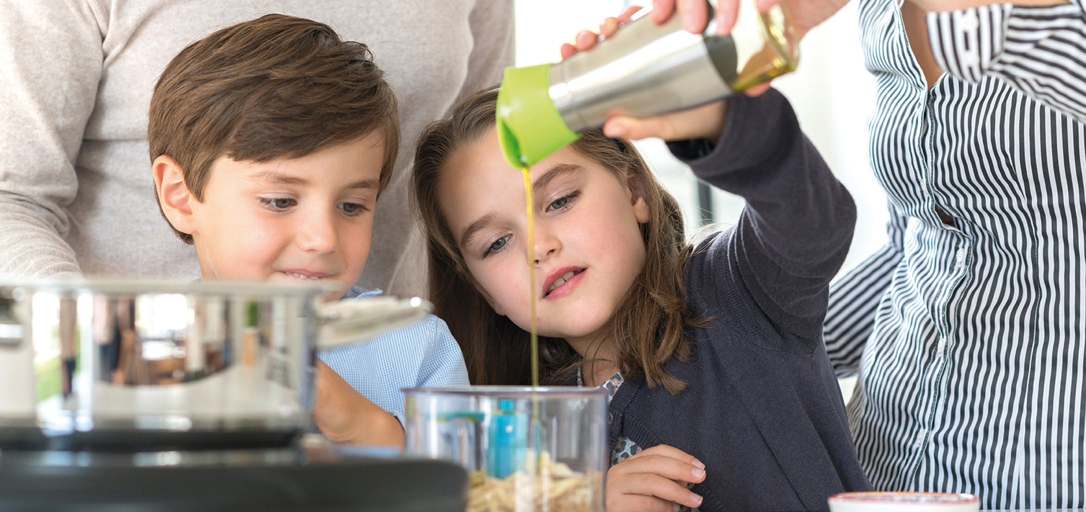 Two kids cooking together with their parents