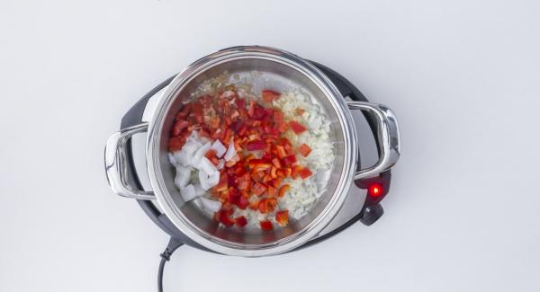 As soon as the Audiotherm beeps on reaching the roasting window, set at low level, add oil and cubes of red pepper and cuttlefish and roast everything together.