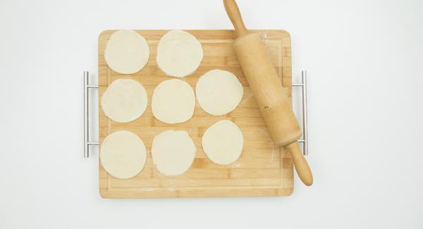 Knead the dough again and roll out thinly on a floured work surface in circles of approx. 10 cm in diameter. Season the filling with salt and add a small amount to the middle of each circle.