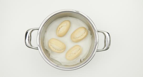 As soon as the Audiotherm beeps on reaching the roasting symbol, switch off Navigenio, place pot in the inverted lid, put in the baking paper and bread rolls on top.