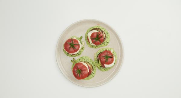 To serve, brush the pesto on the plate and a turret of vegetables on top. Finally, place the tomatoes on top and serve warm.