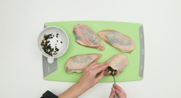 With the chicken breasts, carefully with the fingers over an opening, separate the skin from the meat and fill in garlic olive mixture, press firmly.