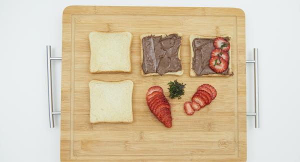 Spread two slices of toast with Nutella. Clean strawberries, cut into thin slices and spread over the toast slices. Cut the mint leaves into strips and pour over them.