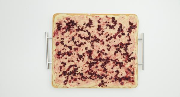 Cut the cherries into small cubes. Roll out the yeast dough thinly into a rectangle on a floured work surface and spread with the jam. Spread the cherries on top and grate the marzipan over it.