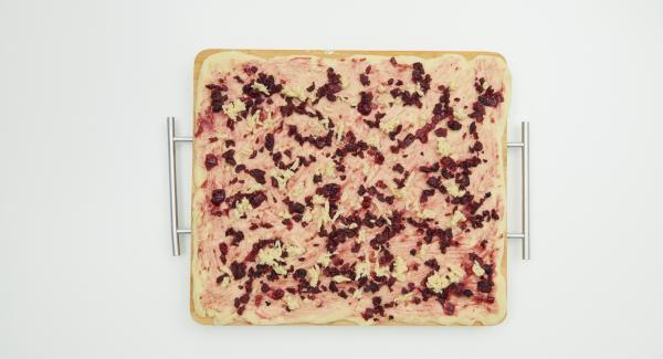 Cut the cherries into small cubes. Roll out the yeast dough thinly into a rectangle on a floured work surface and spread with the jam. Spread the cherries on top and grate the marzipan over it.