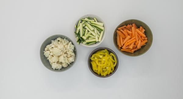 Peel the carrots, clean the zucchini and pepper and cut everything into strips. Clean the cauliflower and cut into small florets.