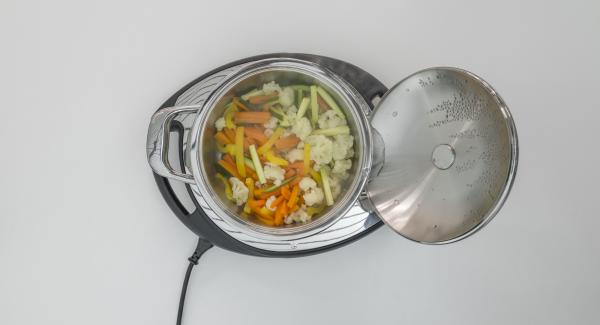 At the end of cooking, spread the crispy mixture over the vegetables and place the pot into the inverted lid.