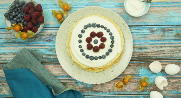 Spread every pancake with the mass and stack each on top of the other. Serve garnished with the remaining mass and some fresh fruits.