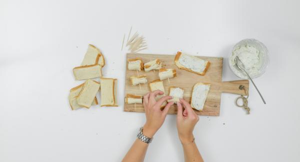 Smear a little cheese cream on the bread strips, roll up, secure with toothpicks.