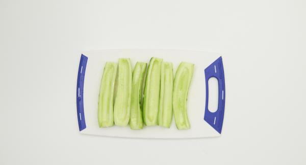 Peel cucumbers, halve lengthwise, remove seeds and cut into thick slices. Peel and halve the onion and cut into thin slices.