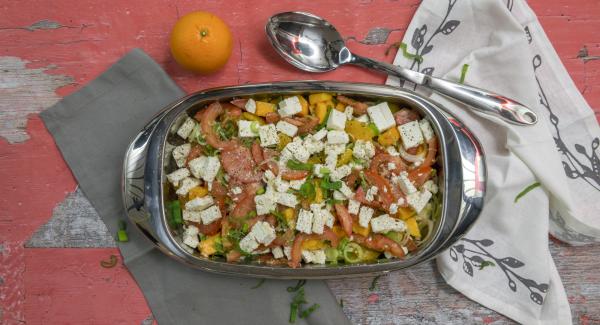 Arrange salad vegetables and fruit in a lasagnera, sprinkle with feta cheese and marinade.