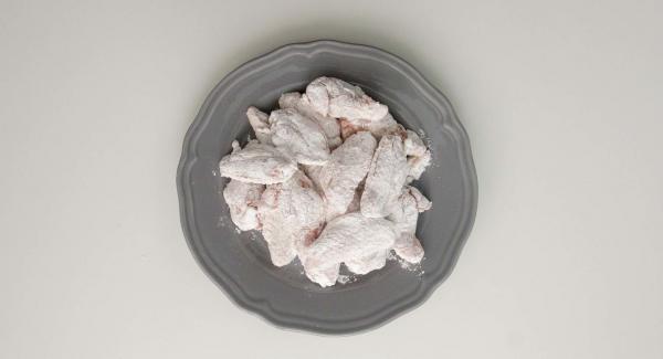 Roll wings in flour, then take them out and remove excess flour by tapping.
