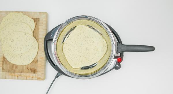 As soon as the Audiotherm beeps on reaching the roasting window, set at level 2, put in the first dough and put on the lid. Bake the first side for approx. 1 minute. Turn the flatbread over and roast for approx. 1 minute.
