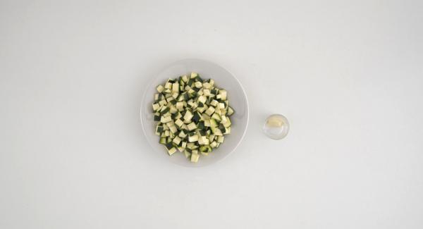 Wash the zucchini and dice them. Peel the garlic clove and clean the shrimps removing the black thread.