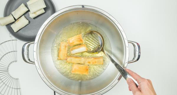 Remove lid, turn the spring rolls, deep-fry until they are golden brown all around. Hang the draining rack on the Wok and let the spring rolls drip off briefly.