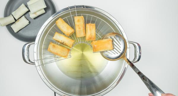 Remove lid, turn the spring rolls, deep-fry until they are golden brown all around. Hang the draining rack on the Wok and let the spring rolls drip off briefly.