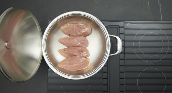 As soon as the Audiotherm beeps on reaching the roasting window, set hob at low level and insert chicken breasts with the skin side down. Put on lid and roast until the turning point at 90 °C has been reached. Press on the remaining garlic with the back of a knife.