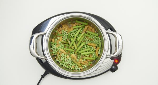 As soon as the Audiotherm beeps on reaching the roasting window, add salsiccia and minced meat and roast. Deglaze with white wine. Stir in the noodles, broth, peas and half of the asparagus. Close with Secuquick softline.