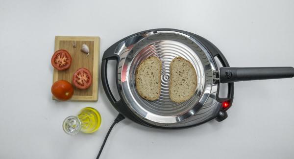Set Navigenio to low level, place 2 slices of bread in the oPan and roast on one side. Turn and rub bread with tomato and garlic.