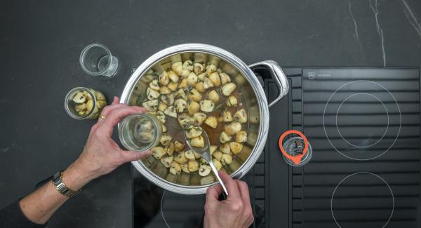 Pour the mushrooms into clean jars and spread the broth over them.