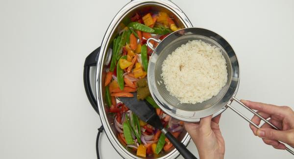 As soon as the Audiotherm beeps on reaching the roasting window, switch to level 2 and fry the vegetables for approx. 3 minutes. Add the curry paste and roast for approx. 2 minutes. Wash the rice well in a sieve with cold water, add to the sugar snap peas and mix well.