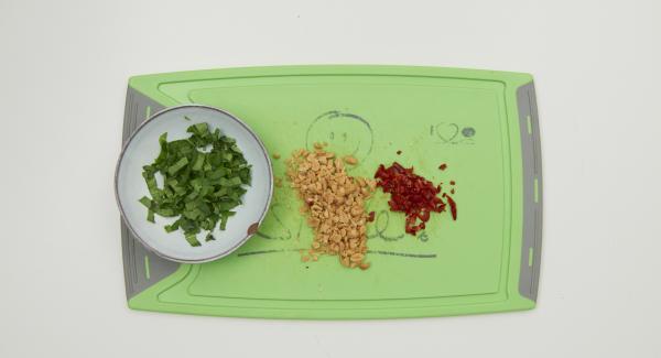 Sprinkle the platter with strips of Thai basil, chopped chilli and coarsely chopped peanuts as desired and serve at the table in the griddle.