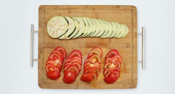 Peel the eggplant in strips and cut it, with tomatoes, into slices (about 0.5 cm thick).
