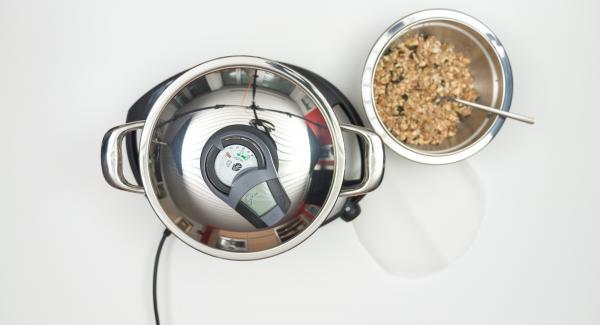 As soon as the Audiotherm beeps on reaching the roasting window, insert baking paper, spread the granola mixture on it and place the pot in the inverted lid.