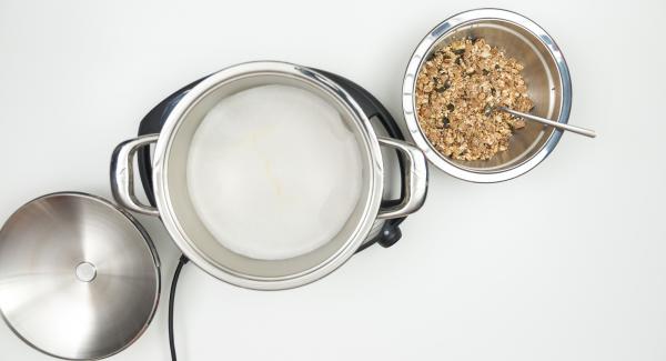 As soon as the Audiotherm beeps on reaching the roasting window, insert baking paper, spread the granola mixture on it and place the pot in the inverted lid.