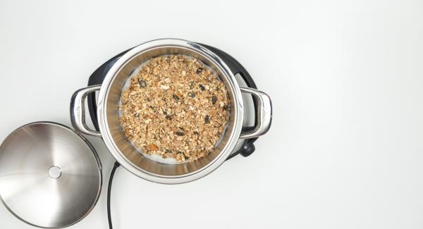 As soon as the Audiotherm beeps on reaching the roasting window, insert baking paper, spread the granola mixture on it and place the pot in the inverted lid.