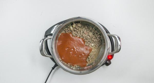 As soon as the Audiotherm beeps on reaching the roasting window, set at level 2 and put in meat with onion-mix and roast until crumbly. Add corn and sieved tomatoes, season and stir well.