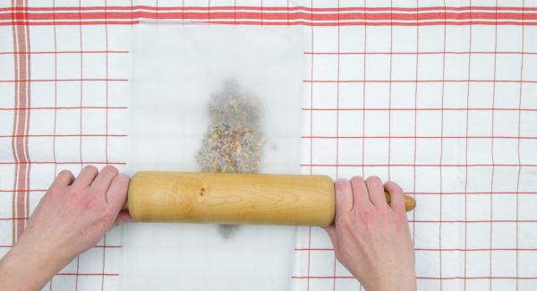 Place brittle mass on one half of the baking paper, fold the second half of the paper over it. Roll out brittle with a rolling pin as flat as possible. Let cool down.