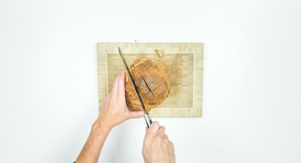 Cut the top of the bread crosswise so that approx. 2 cm squares are formed. It is important that the bread is not cut all the way to the bottom.
