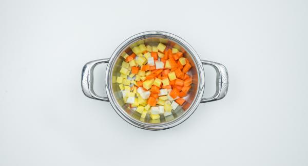 Put the potato, carrot and celery cubes dripping wet in the pot, spread leek rings and tomato cubes over them.