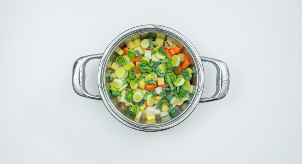 Put the potato, carrot and celery cubes dripping wet in the pot, spread leek rings and tomato cubes over them.