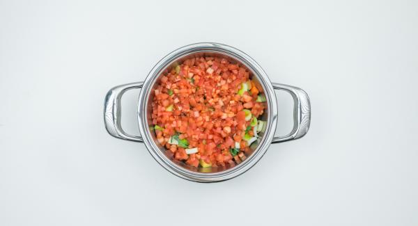 Put the potato, carrot and celery cubes dripping wet in the pot, spread leek rings and tomato cubes over them.