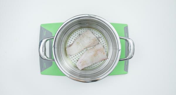 Grease the Combi sieve insert, cut the fish fillet in half, season with salt and pepper and place into Combi sieve. Wash the lemon, cut it into slices and place it on the fish.