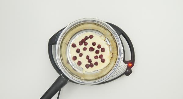 As soon as the Audiotherm beeps when reaching the roasting window, switch to level 2 and add approx. 1 teaspoon of roasting butter to the pan. Put 1/4 batter into the pan and spread 1/4 cherries over it.