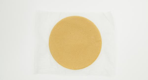 Roll out the dough on a sheet of baking paper around 28 cm in size (using a 28 cm lid). Cut out a circle of baking paper with a diameter of 24 cm (using the lid 24 cm). Place this circle on the dough sheet.