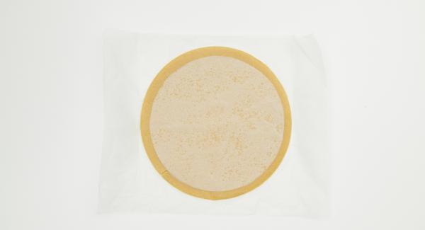 Roll out the dough on a sheet of baking paper around 28 cm in size (using a 28 cm lid). Cut out a circle of baking paper with a diameter of 24 cm (using the lid 24 cm). Place this circle on the dough sheet.
