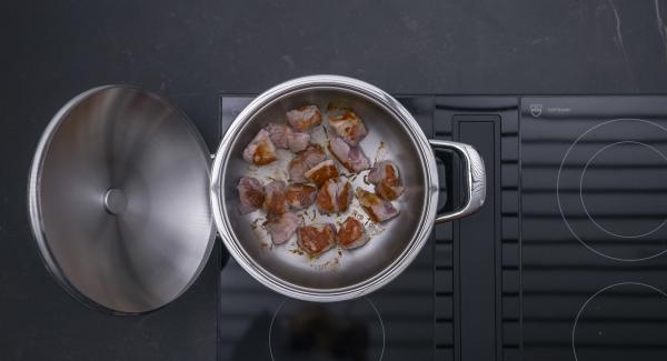 As soon as the Audiotherm beeps when reaching the roasting window, switch to low level and roast goulash all around. Add the onion mixture and roast briefly.