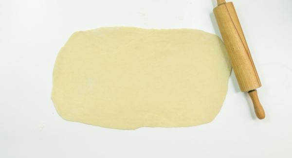 Mix the ingredients for the filling. Roll out the yeast dough into a rectangle, spread the filling on top and roll up from the long side.
