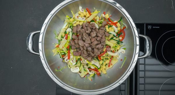 Briefly roast the vegetables while stirring, add the beef again and season with salt and pepper.