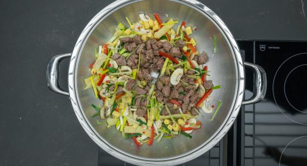 Briefly roast the vegetables while stirring, add the beef again and season with salt and pepper.